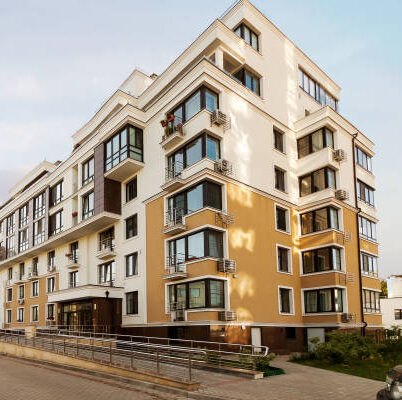 Real estate low rise construction building exterior in new residential area for sale blue sky sunny background. Urban development concept image